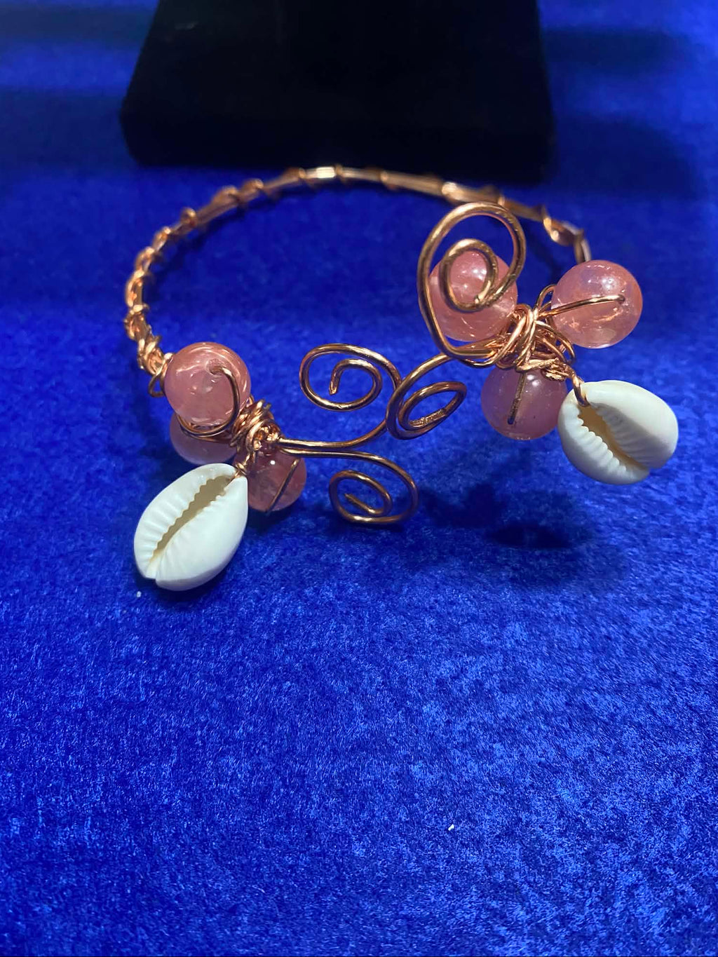copper wire bracelet with pink beads and cowrie shells
